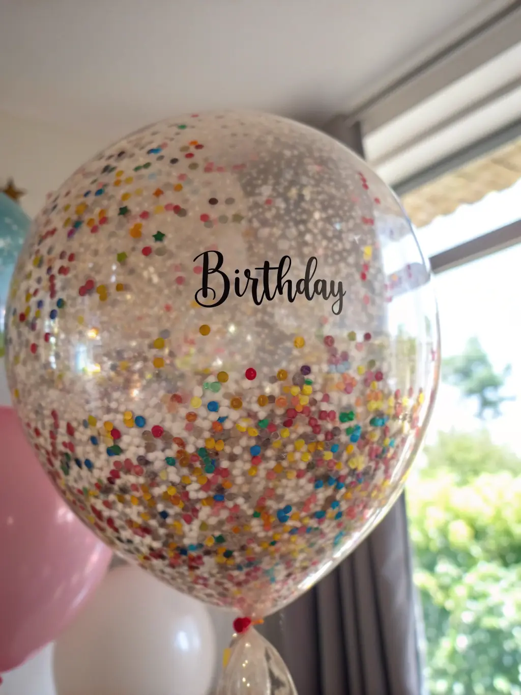 A vibrant image showcasing a variety of colorful balloons, streamers, and confetti, perfect for a birthday party, displayed in Kitty's Party's shop.